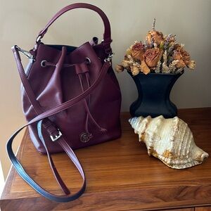 Tommy Hilfiger burgundy faux leather bag with handle and single shoulder strap.